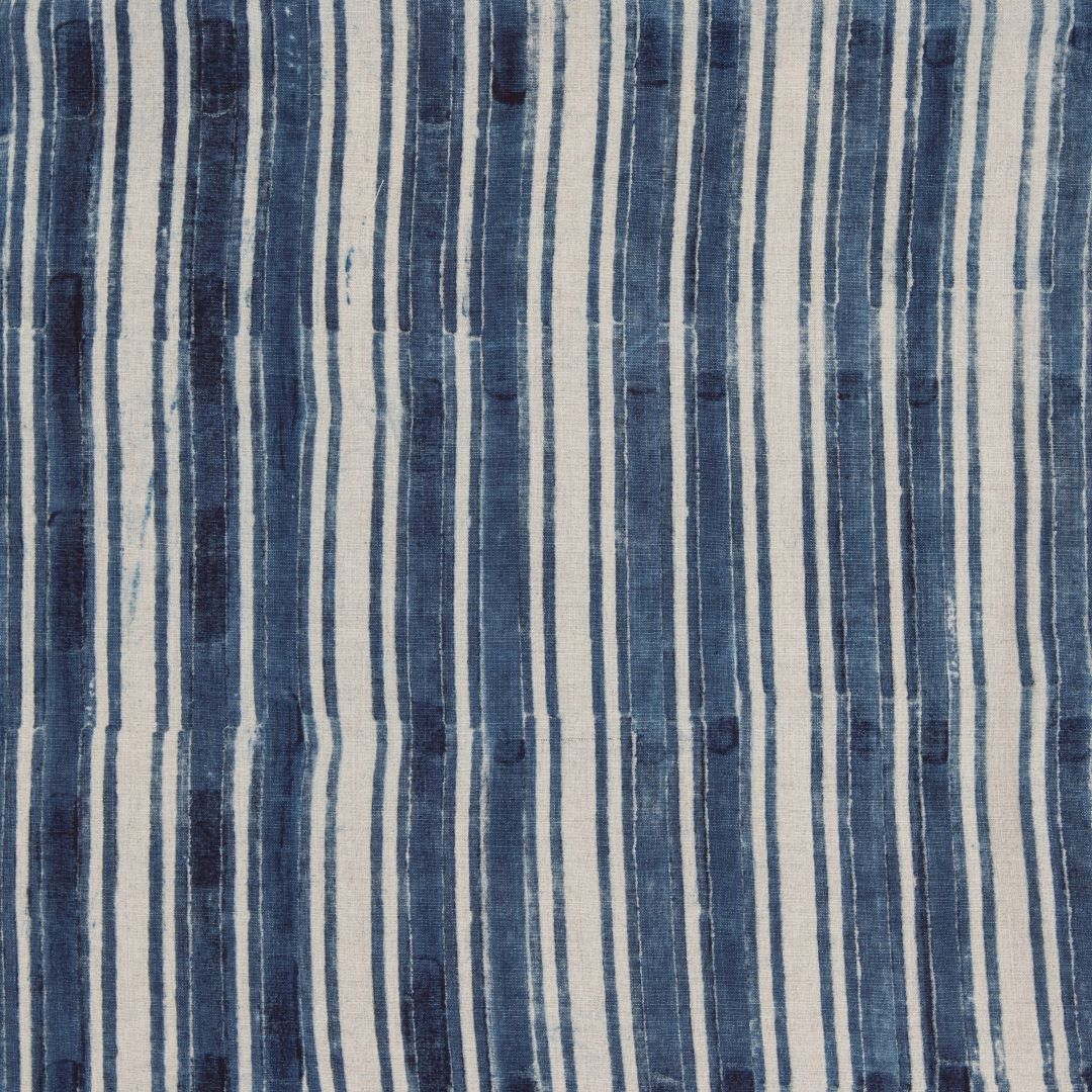 Detail of fabric in a painterly stripe print in navy on a cream field.