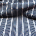 Detail of a draped hand-woven cotton striped fabric in shades of blue and beige.