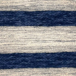 A flatweave rug with stripes of grey and ivory alternating with raised woven strips in shades of dark blue.