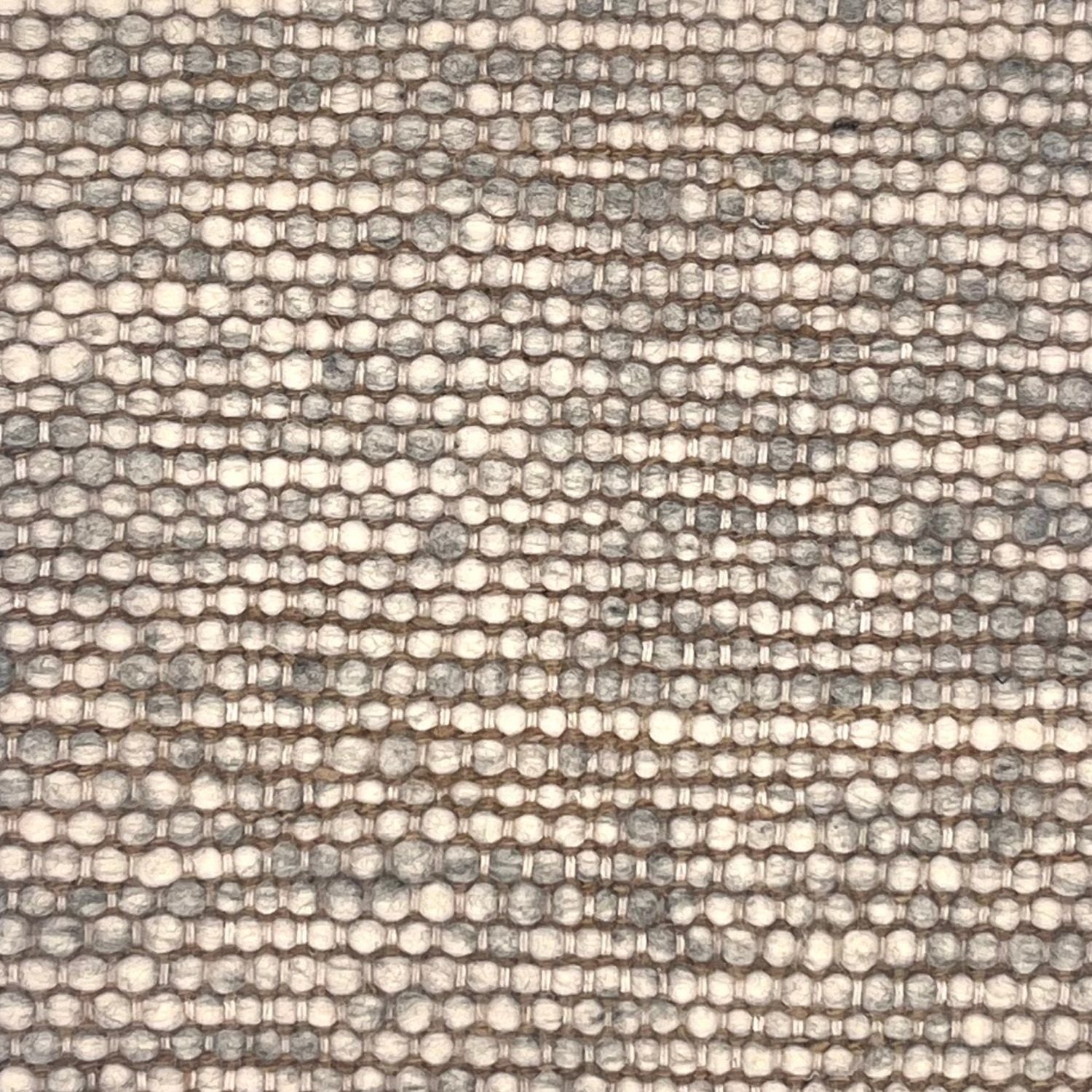 A rug woven in rows with yard that is a melange of ivory and grey.