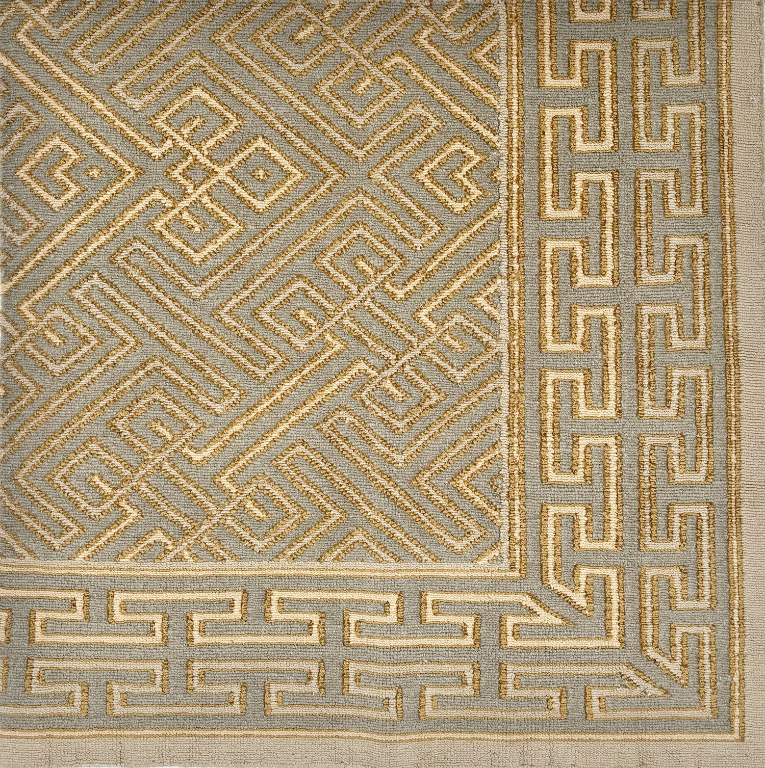 Handknotted rug with a greek key pattern in grey, ochre and ivory. 