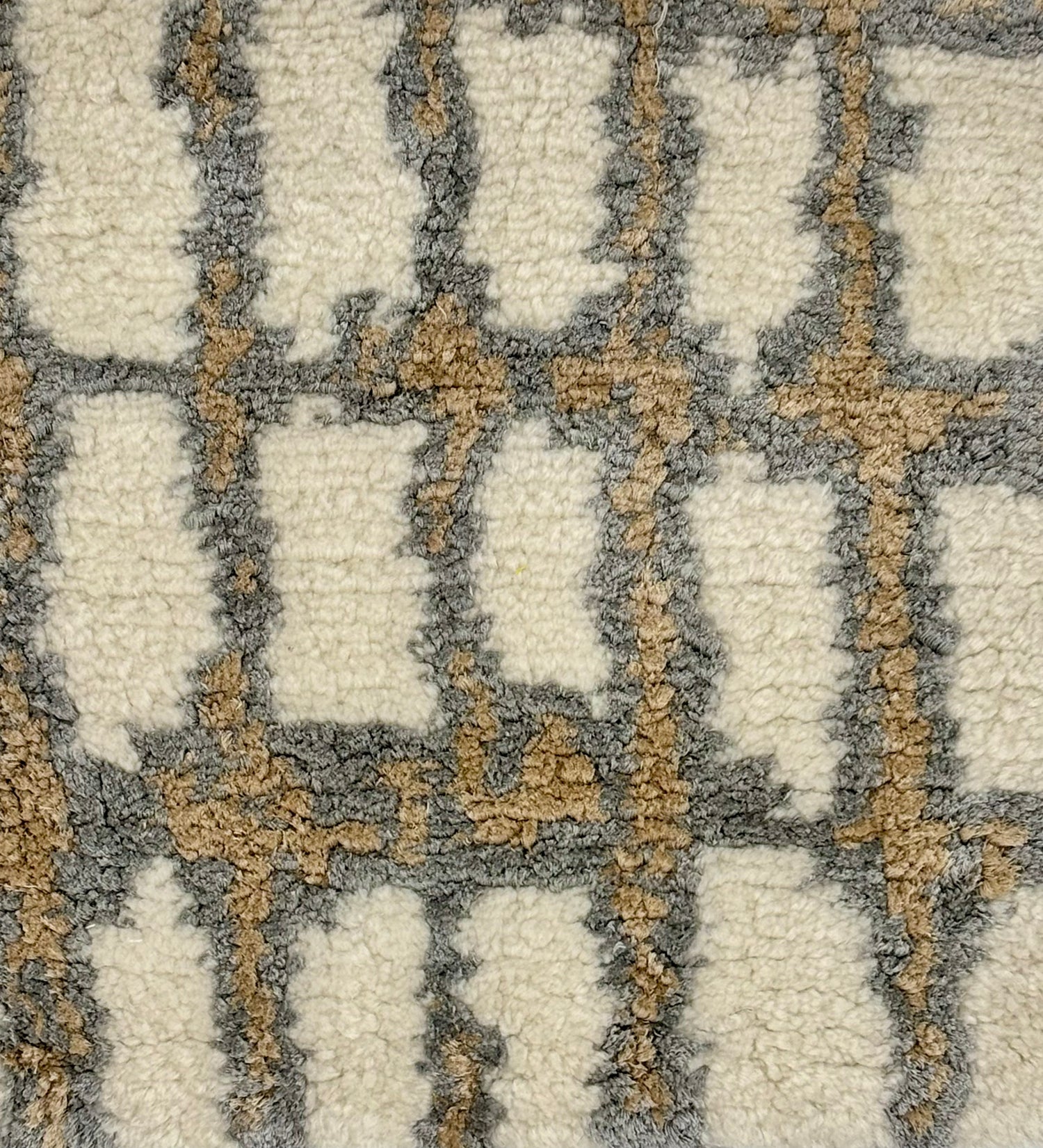 Handknotted rug sample in an abstract textural design in white, grey and tan.