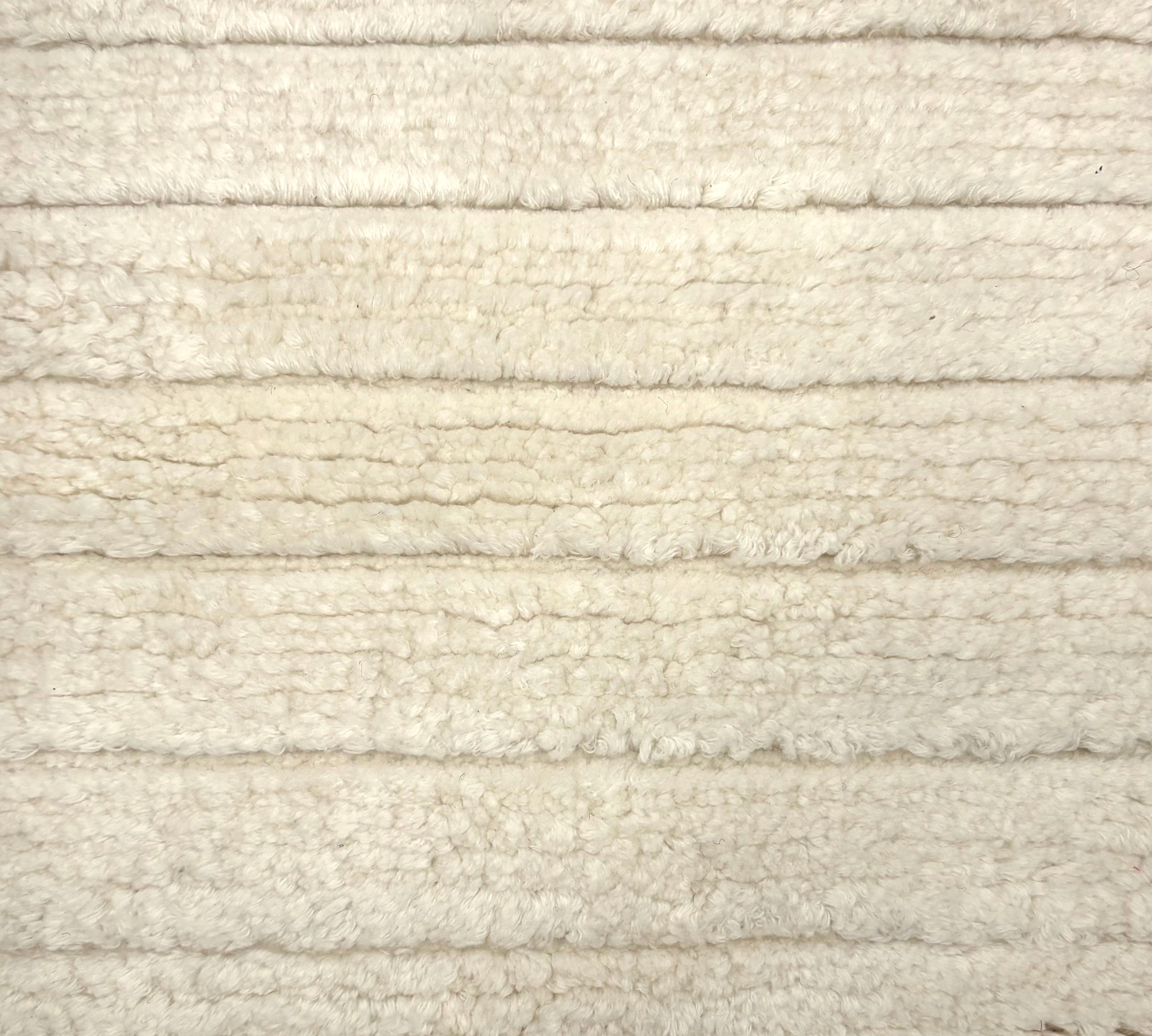 Handknotted rug in a cut pile & loop stripe in cream. 