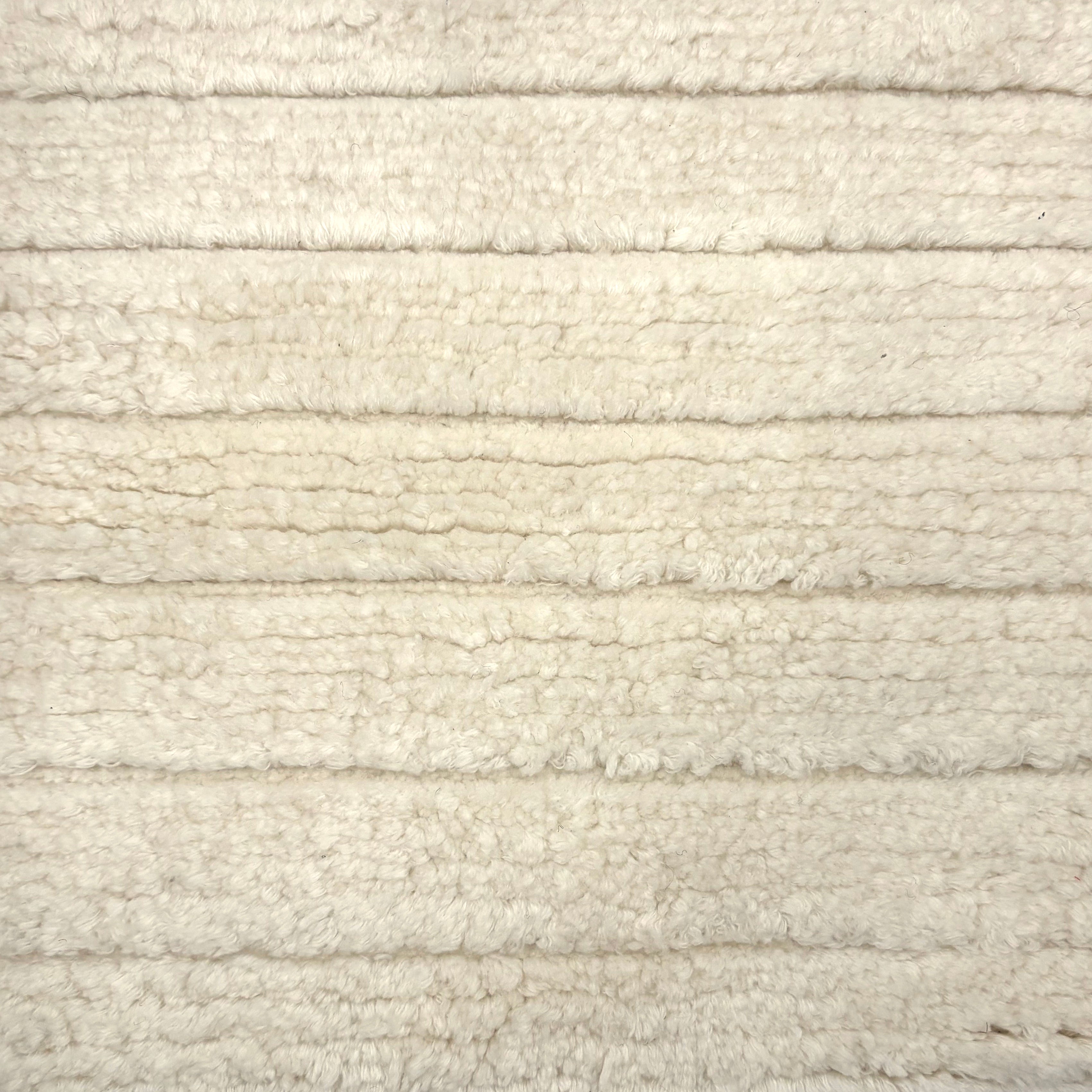 Handknotted rug in a cut pile & loop stripe in cream. 