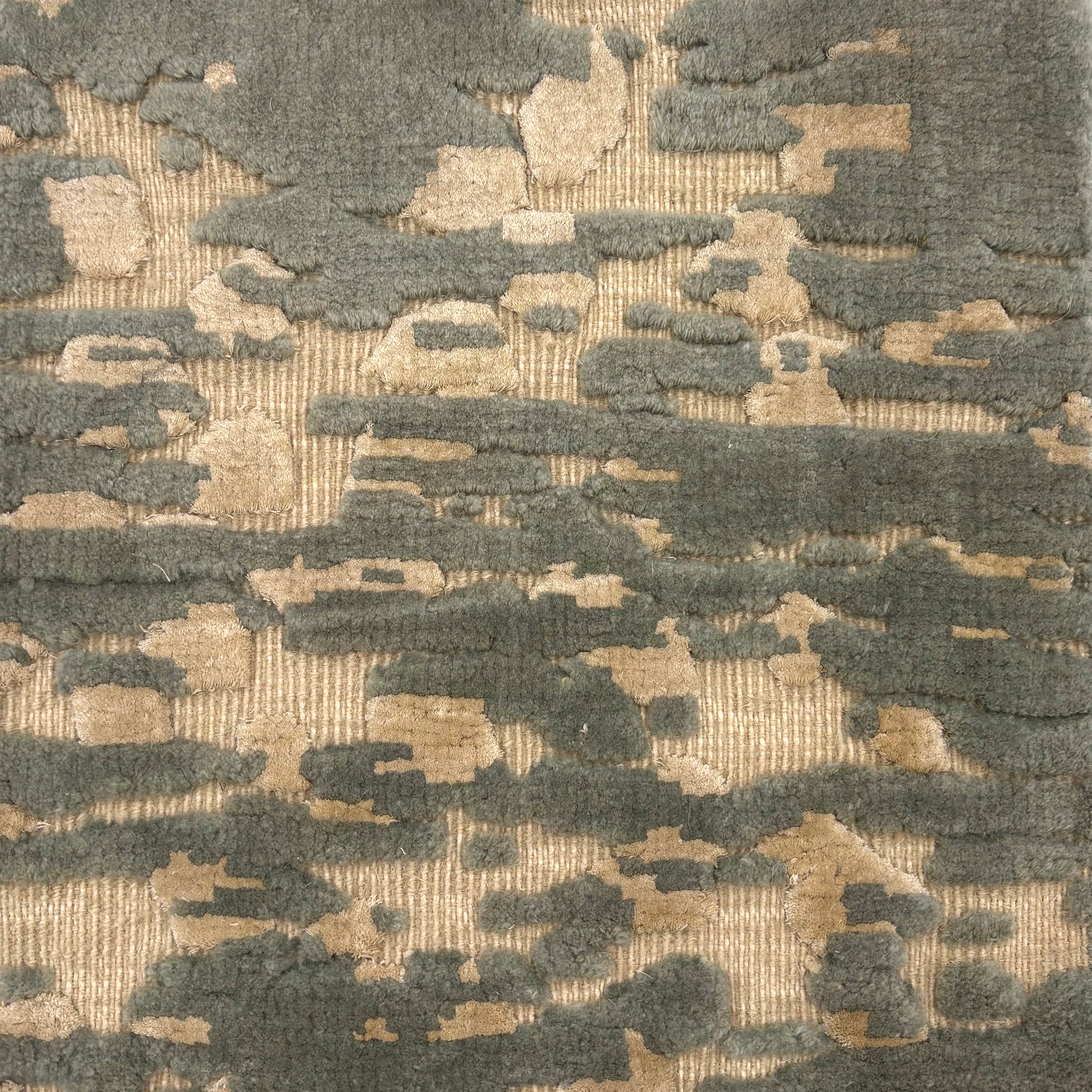 Handknotted rug in an abstract textural design in muted teal and cream.