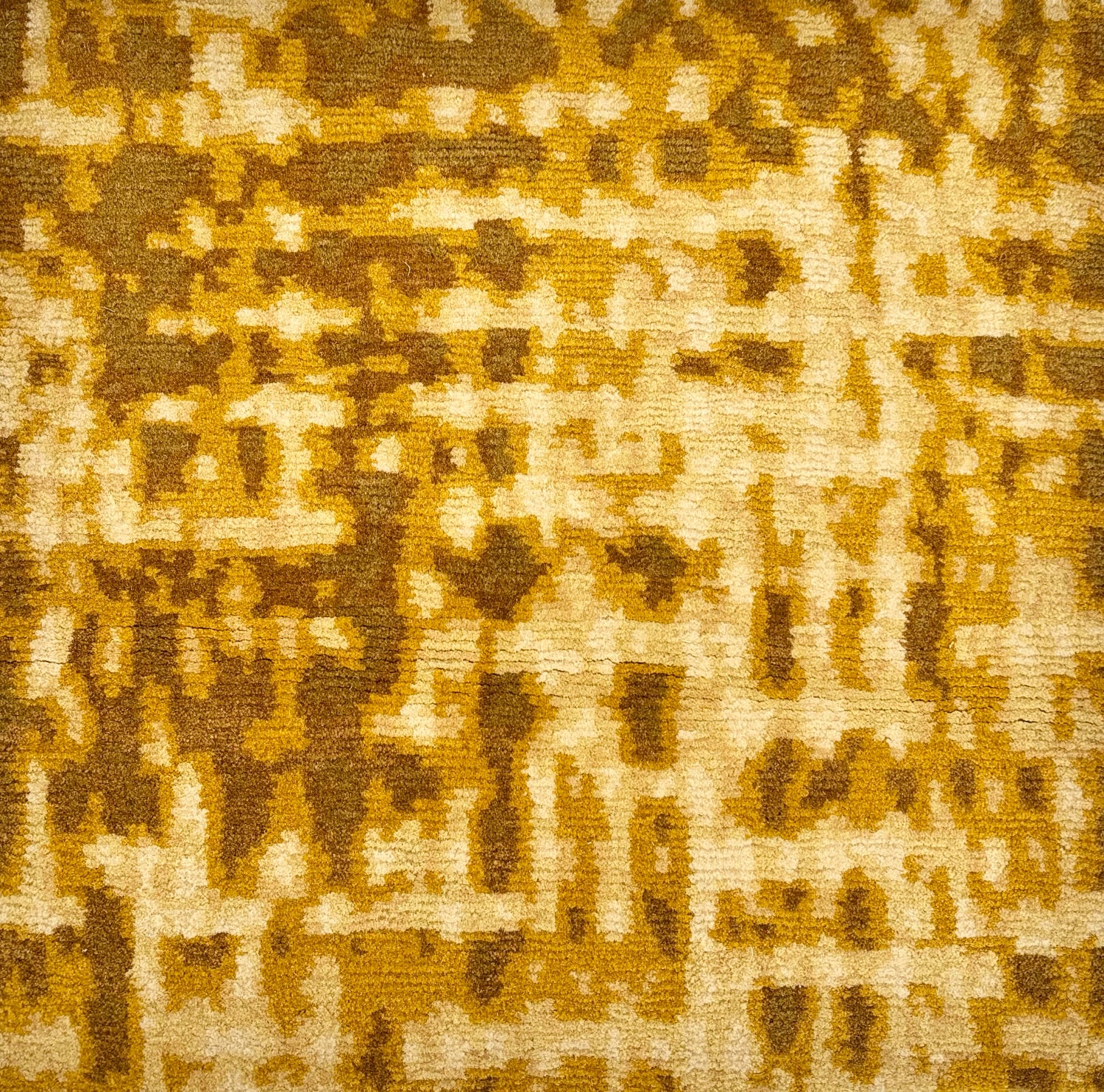 Handknotted rug sample in an abstract textural design in shades of yellow and tan.