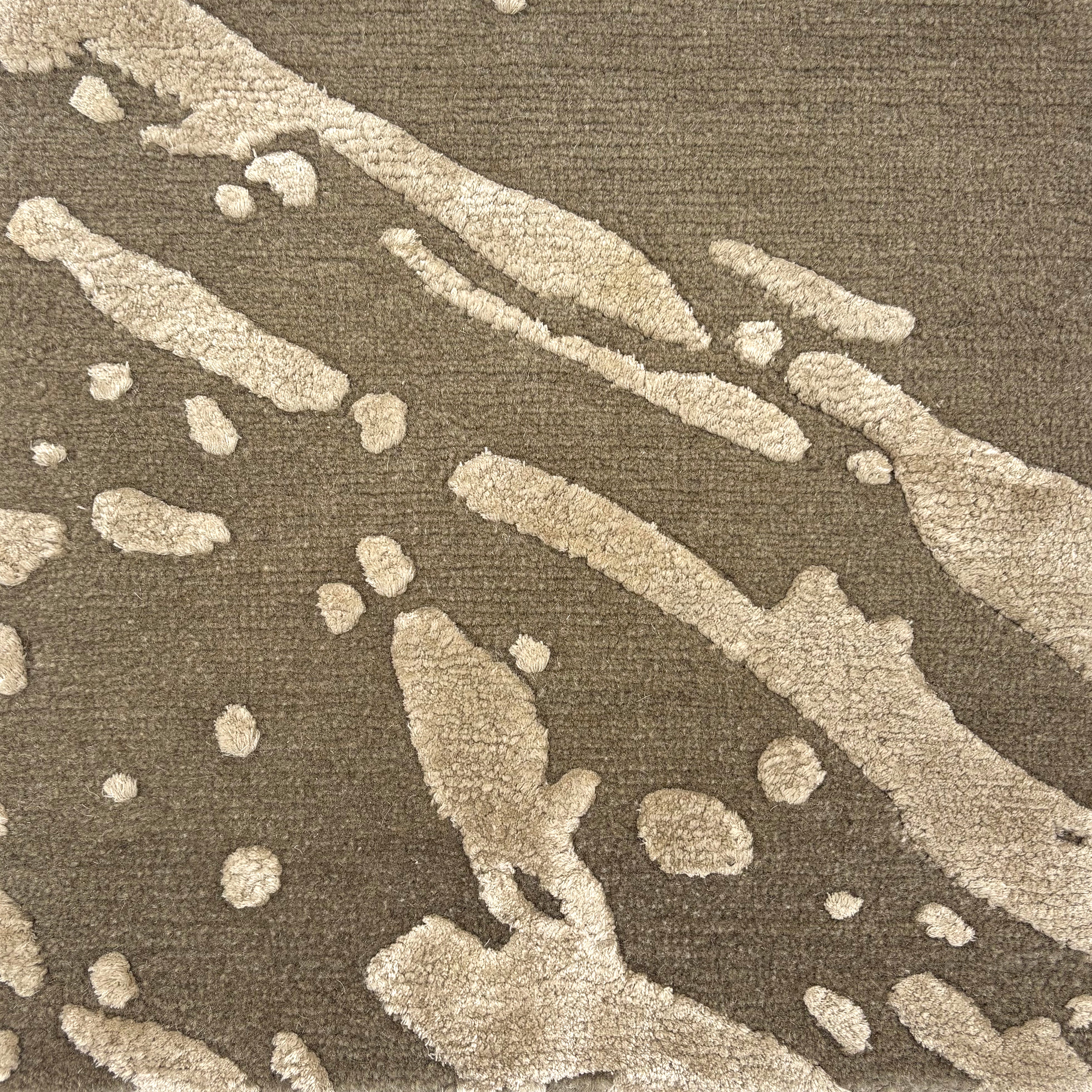 Handknotted rug in an abstract paint splatter design in taupe wool and silk. 