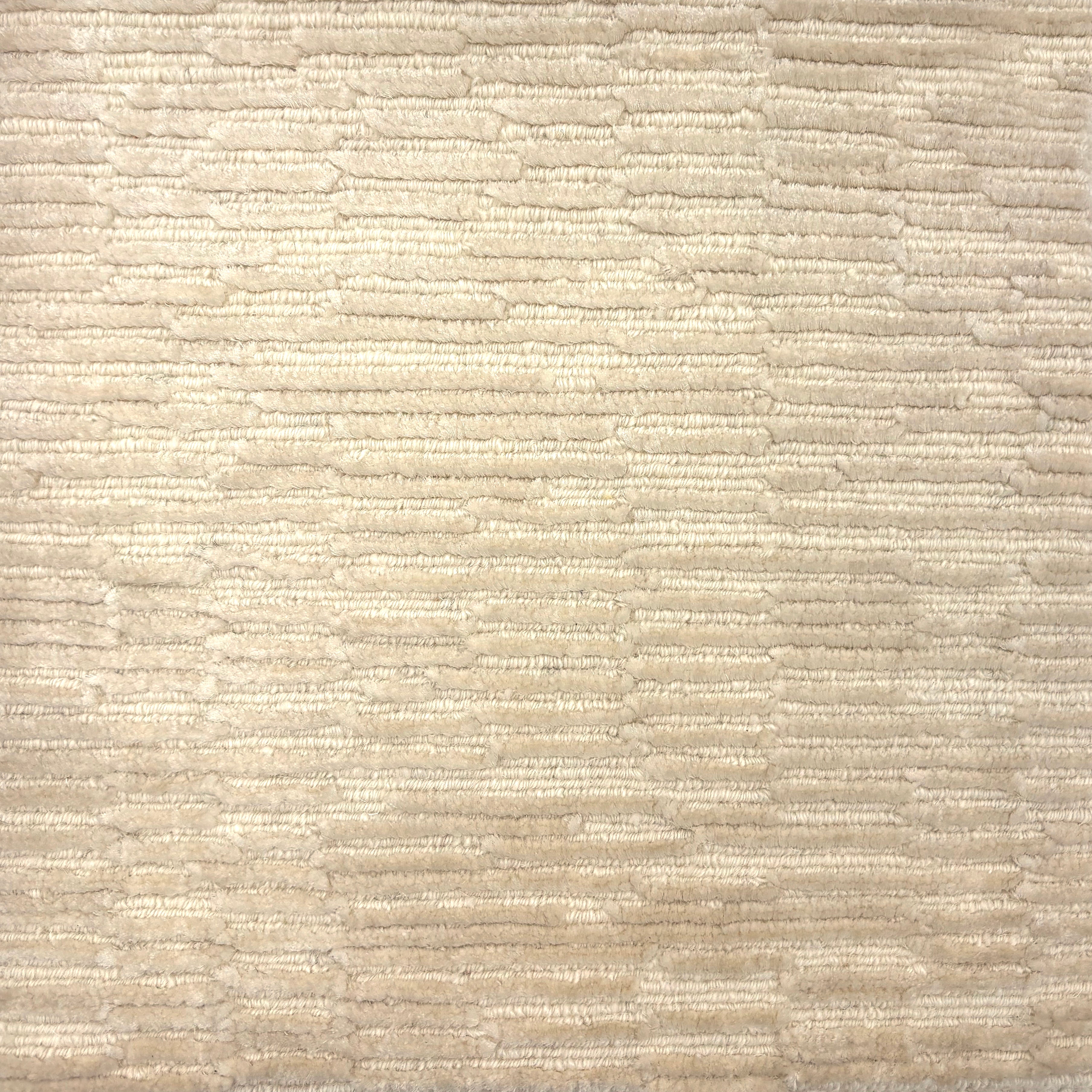 Handknotted rug in a textural hi lo pattern in cut pile and loop in cream. 