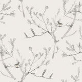 Detail of fabric in a painterly bird and branch pattern in shades of gray on a greige field.