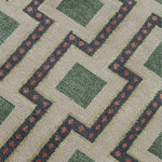 Close-up of a patterned carpet with green squares and red accents.