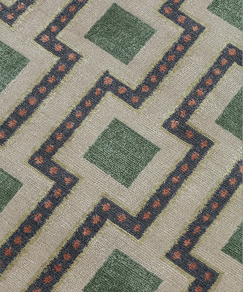 Close-up of a patterned carpet with green squares and red accents.