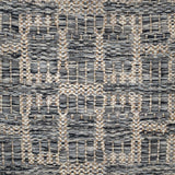 Handwoven rug detail in a geometric design in grey and beige