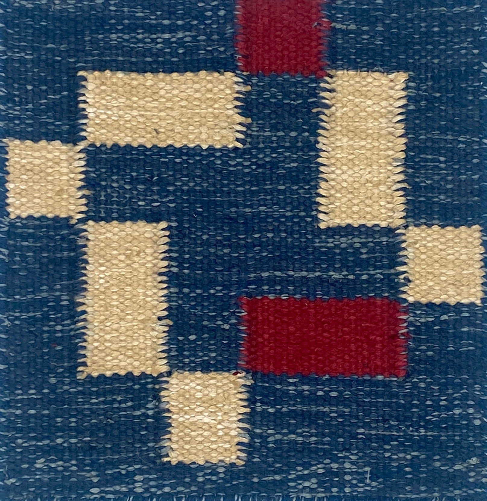 Flatweave rug in geometric pattern in blue and cream on a blue field. 