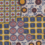 Detail of fabric in a dense curvilinear print in shades of blue, red and yellow on a tan field.