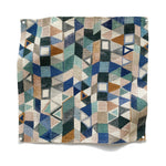 Square fabric swatch in a small-scale playful geometric print in shades of blue, green, gray and tan.