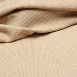 Detail of a draped hand-woven cotton striped fabric in cream and tan.