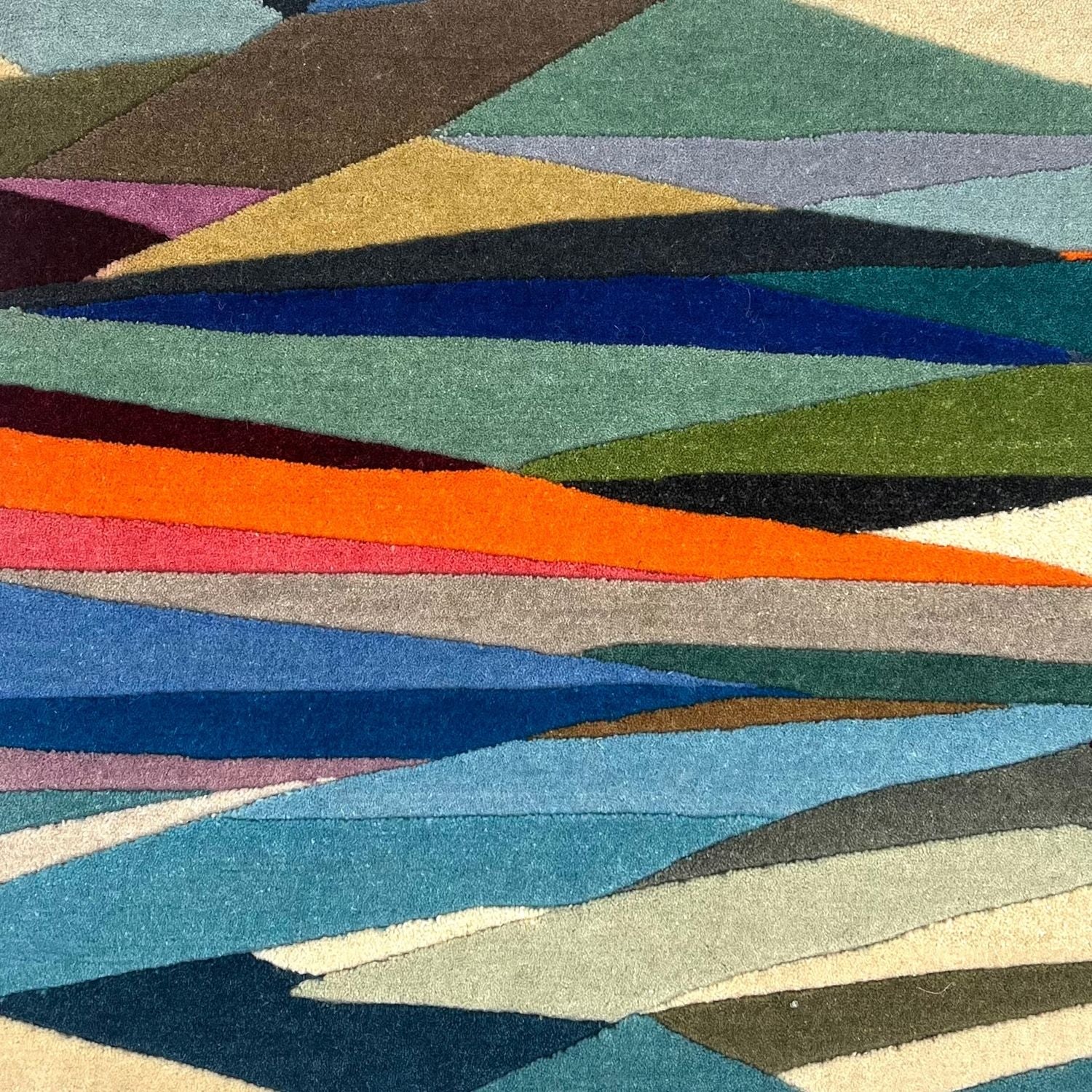 A multi colored rug with organic geometric shapes in many colors.