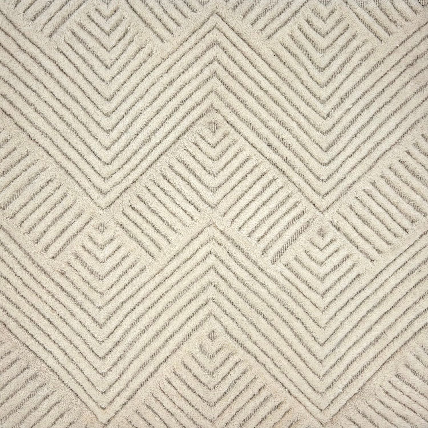 An ivory rug with a repeating raised chevron pattern on an ivory ground.