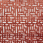 Handknotted rug sample with a geometric lattice pattern in rust red on a white field.