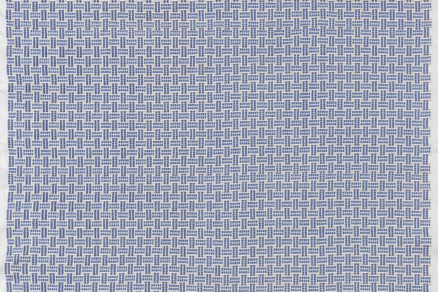 Embroidered fabric with a basketweave design in blue on a white field. 