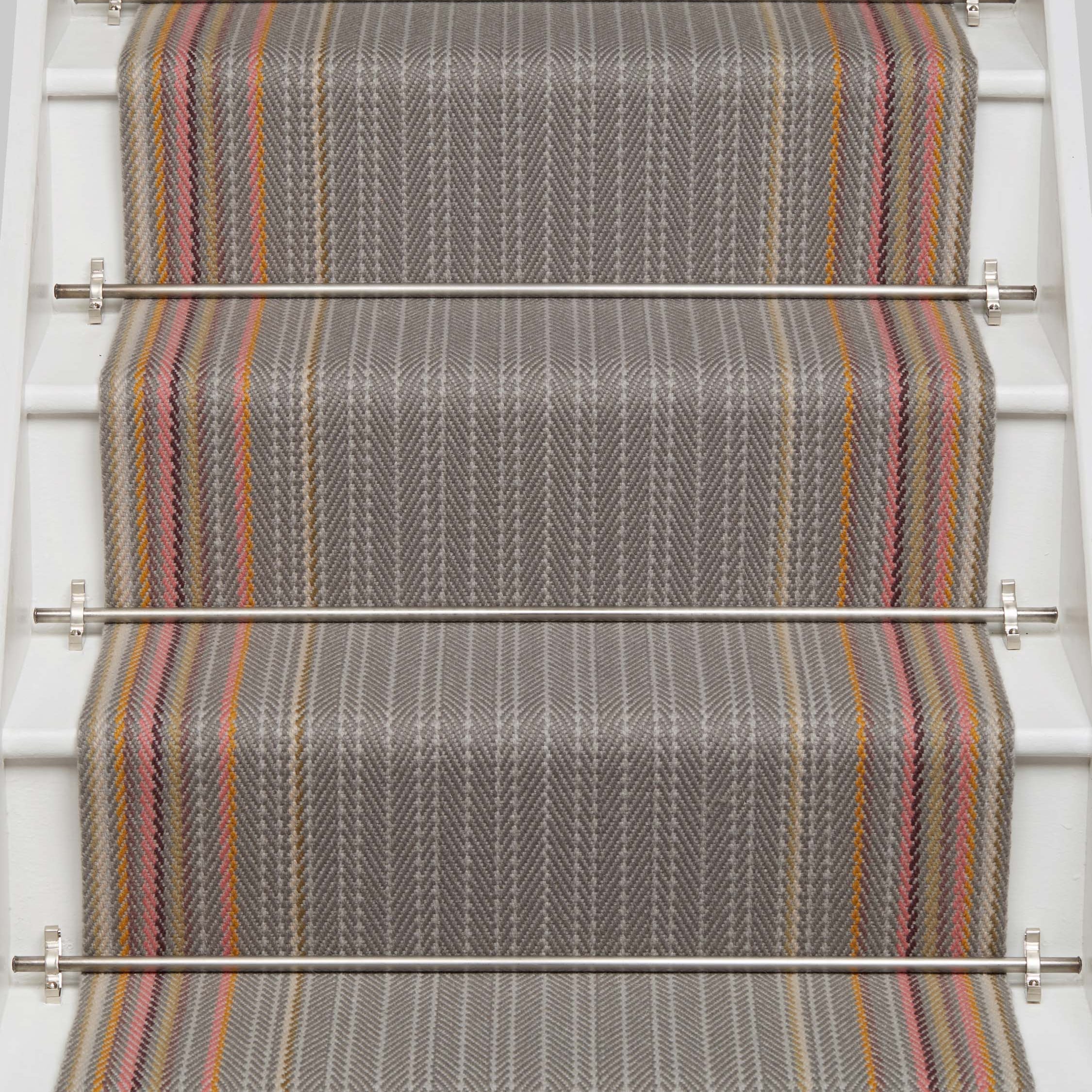 Striped flatweave runner in grey with pink orange and tan on white staircase