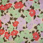 Detail of fabric in a painterly floral print in shades of pink, red, green and tan.