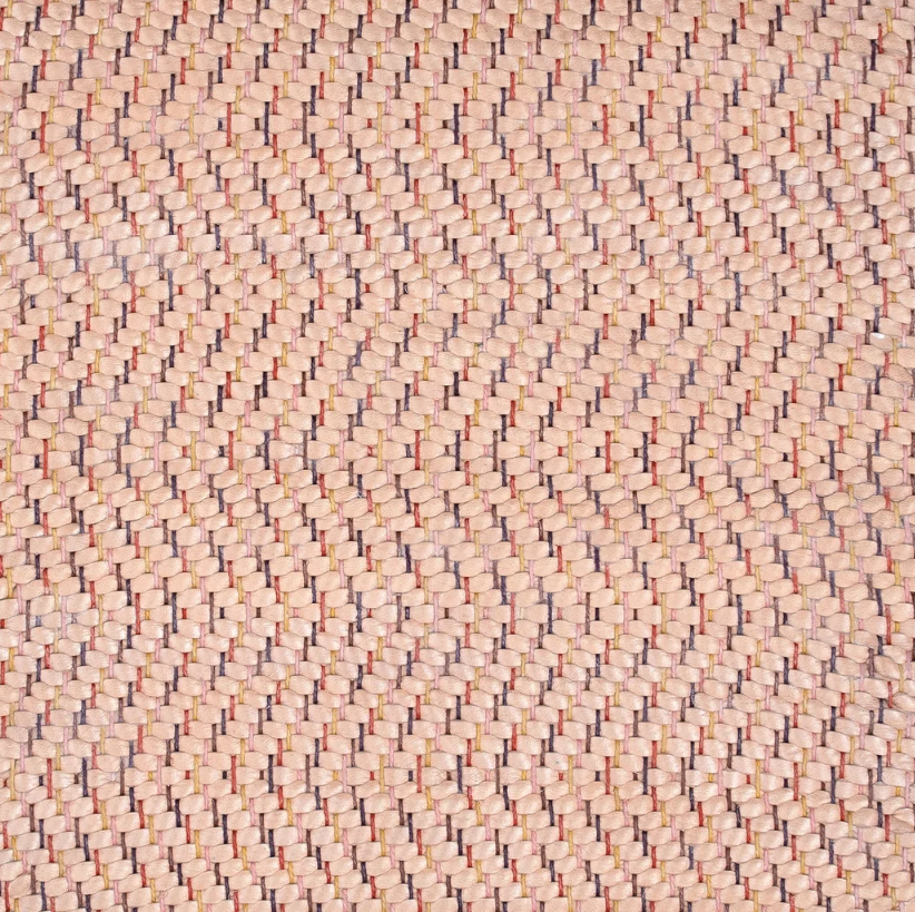 Detail of a woven leather rug in a herringbone pattern in light pink with red and purple accents.