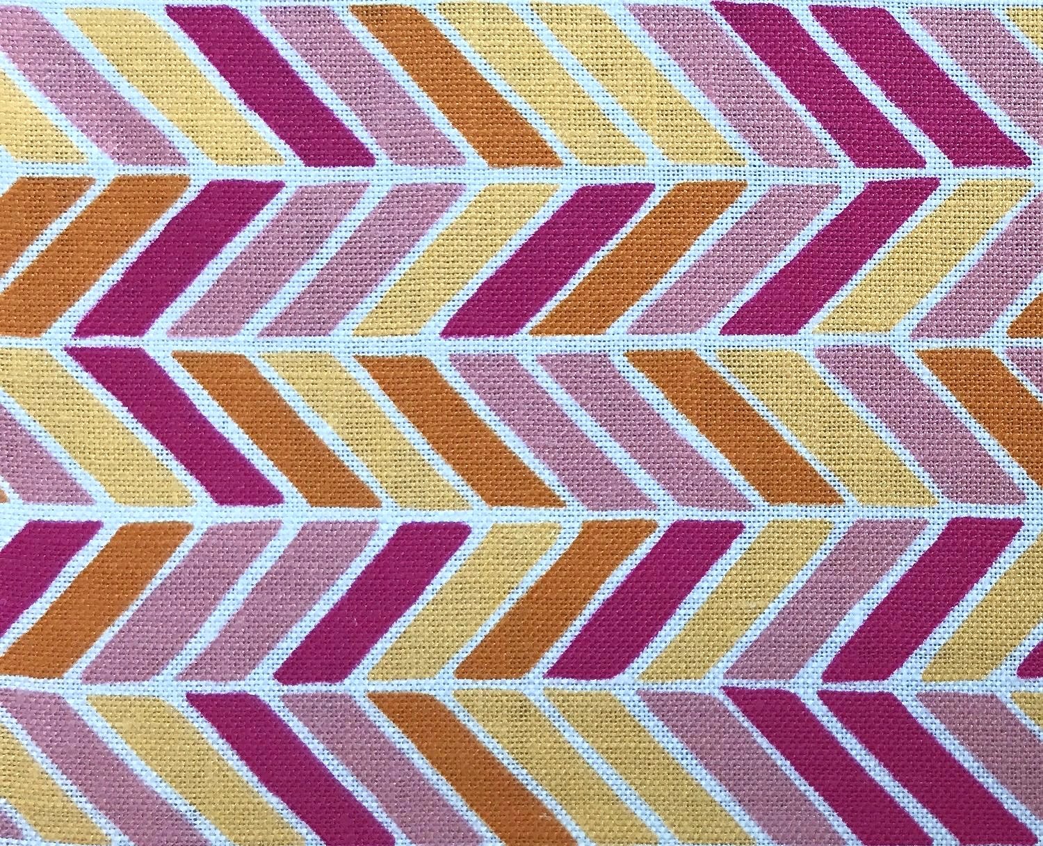 Detail of fabric in a geometric herringbone print in pink, orange and yellow on a white field.