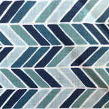 Detail of fabric in a geometric herringbone print in blue, turquoise and navy on a white field.