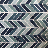 Detail of fabric in a geometric herringbone print in blue, turquoise and navy on a white field.