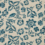 Detail of fabric in a floral print in shades of blue and navy on a tan field.