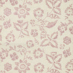 Detail of fabric in a floral print in shades of pink on a tan field.