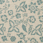 Detail of fabric in a floral print in shades of teal on a tan field.