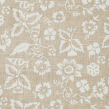 Detail of fabric in a floral print in shades of white on a tan field.