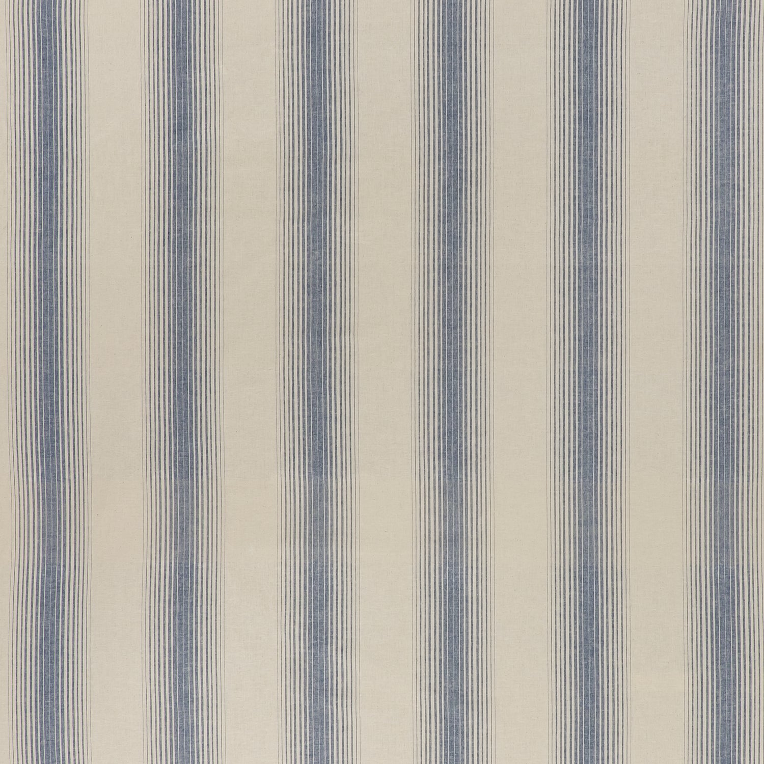 printed cotton fabric in an irregular stripe pattern in blue on a cream field.