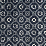 Detail of a cotton fabric in a floral gridded honeycomb pattern in white on an indigo field.