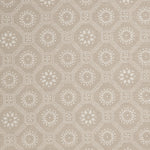 Detail of a cotton fabric in a floral gridded honeycomb pattern in white on a beige field.