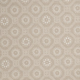 Detail of a cotton fabric in a floral gridded honeycomb pattern in white on a beige field.