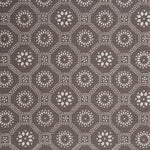 Detail of a cotton fabric in a floral gridded honeycomb pattern in white on a brown field.