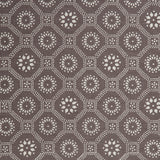 Detail of a cotton fabric in a floral gridded honeycomb pattern in white on a brown field.