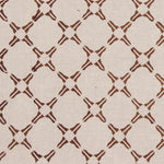 Detail of fabric in a geometric lattice print in rust on a tan field.