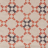 Detail of fabric in a geometric lattice print in orange and navy on a tan field.