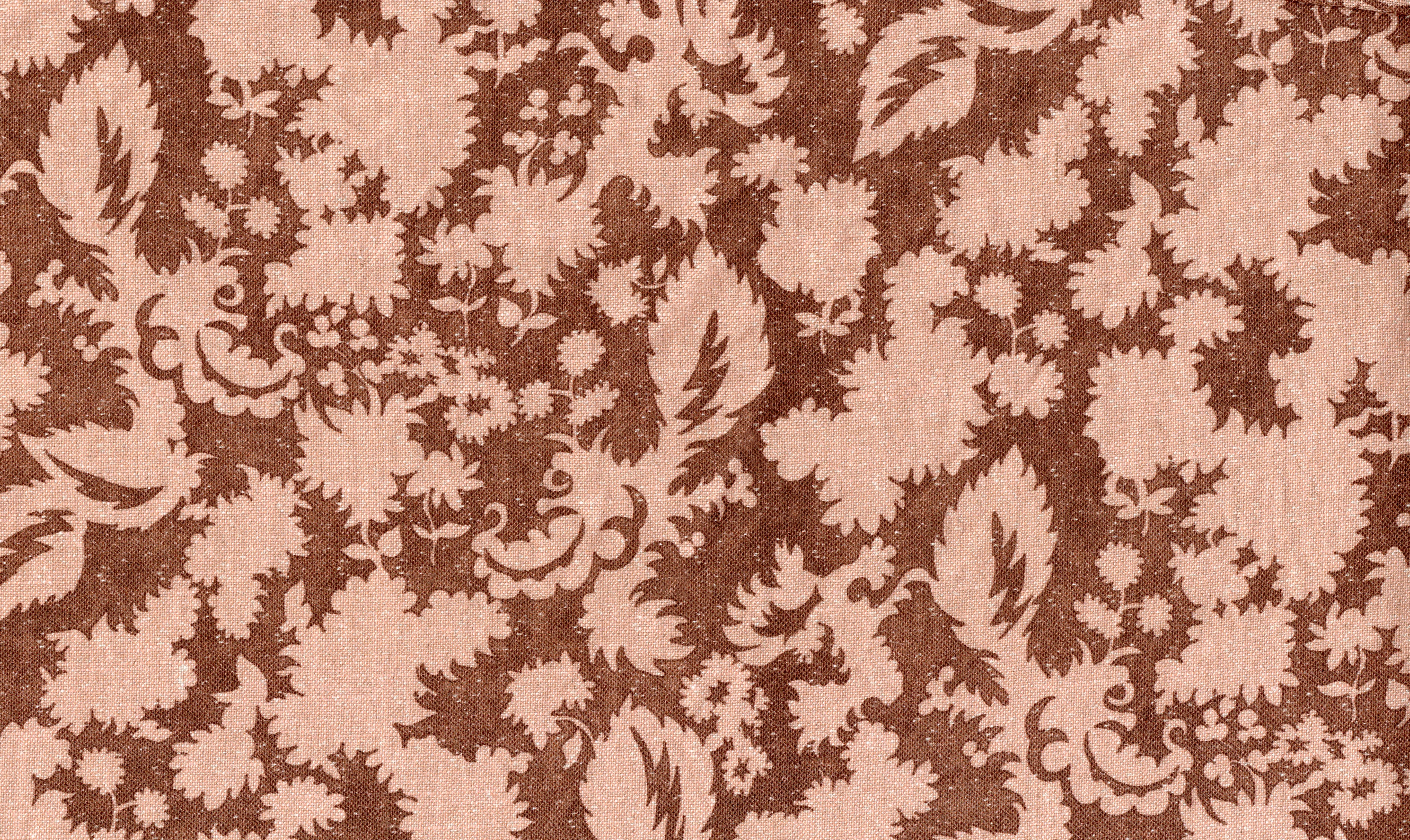 Printed linen in a blush pink floral silhouette motif on rust brown field. 