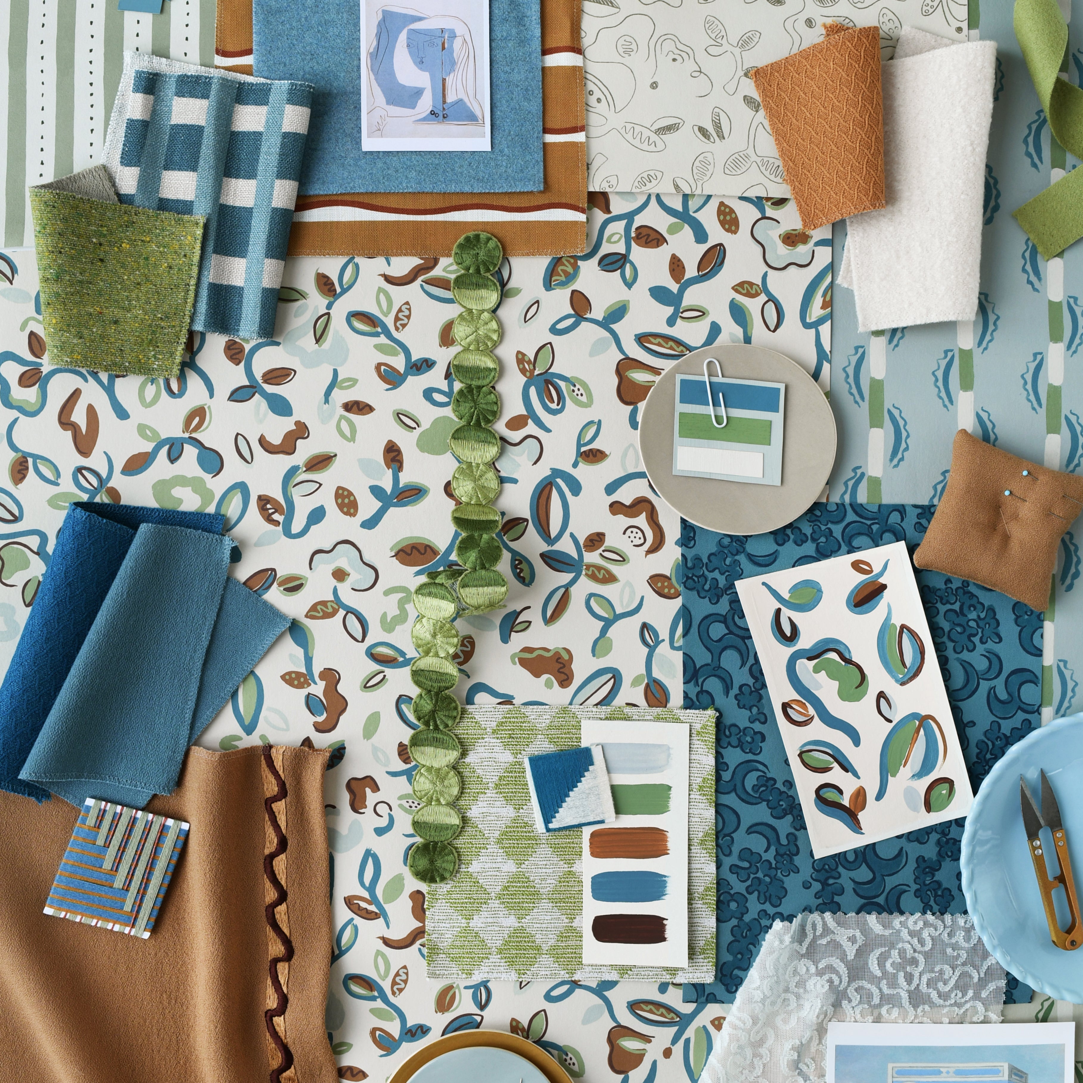 Collection of fabric swatches and design elements in blue, green, and brown on a patterned background.