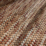 Detail of a woven leather rug in a striped grid texture in shades of brown.