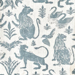 Close-up of fabric in a lion and plant print in blue-gray on a mottled white field.