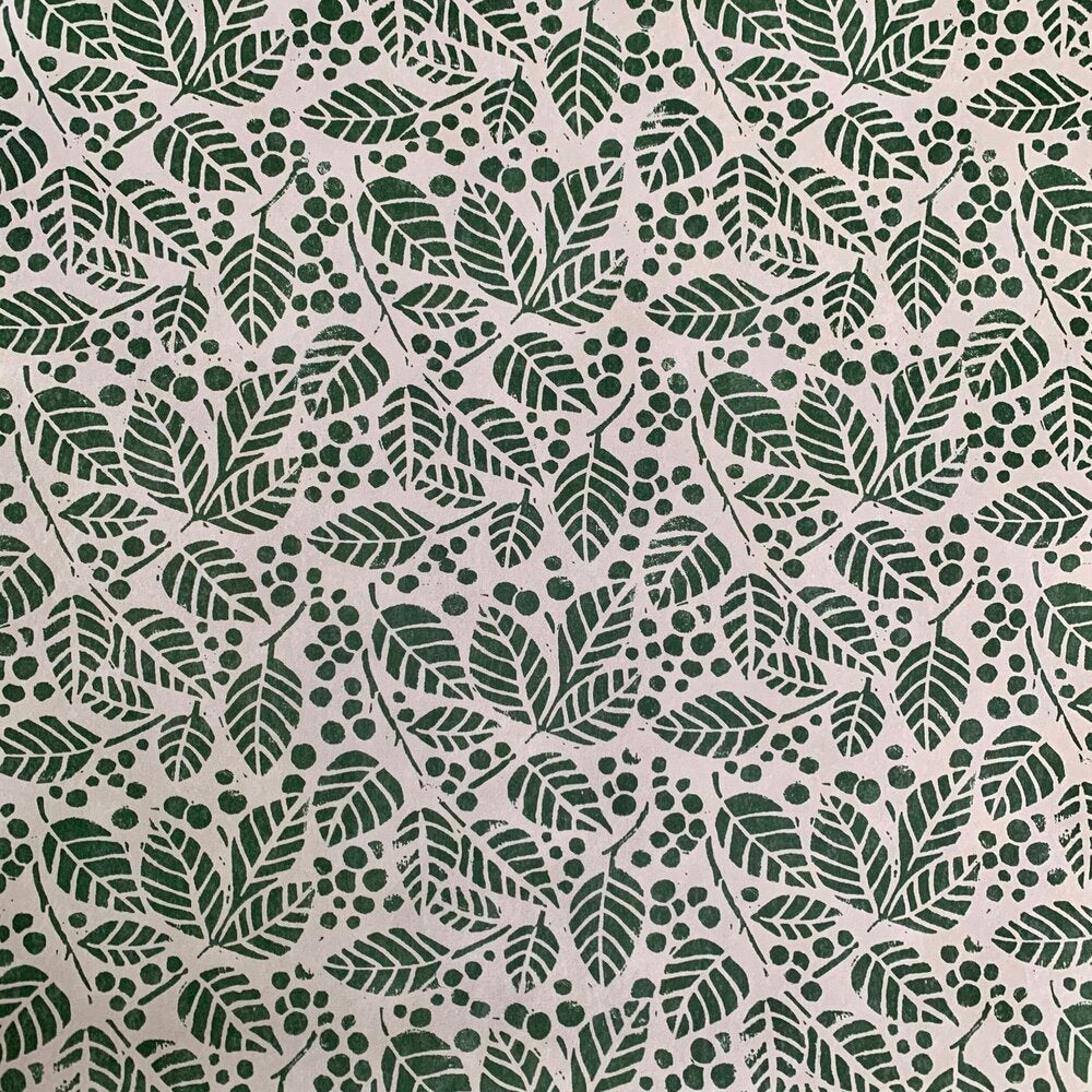 Detail of wallpaper in a repeating leaf print in dark green on a white field.