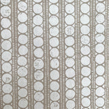 Detail of wallpaper in a circle and stripe print in white on a oatmeal field.