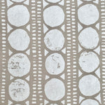 Detail of wallpaper in a circle and stripe print in white on a oatmeal field.