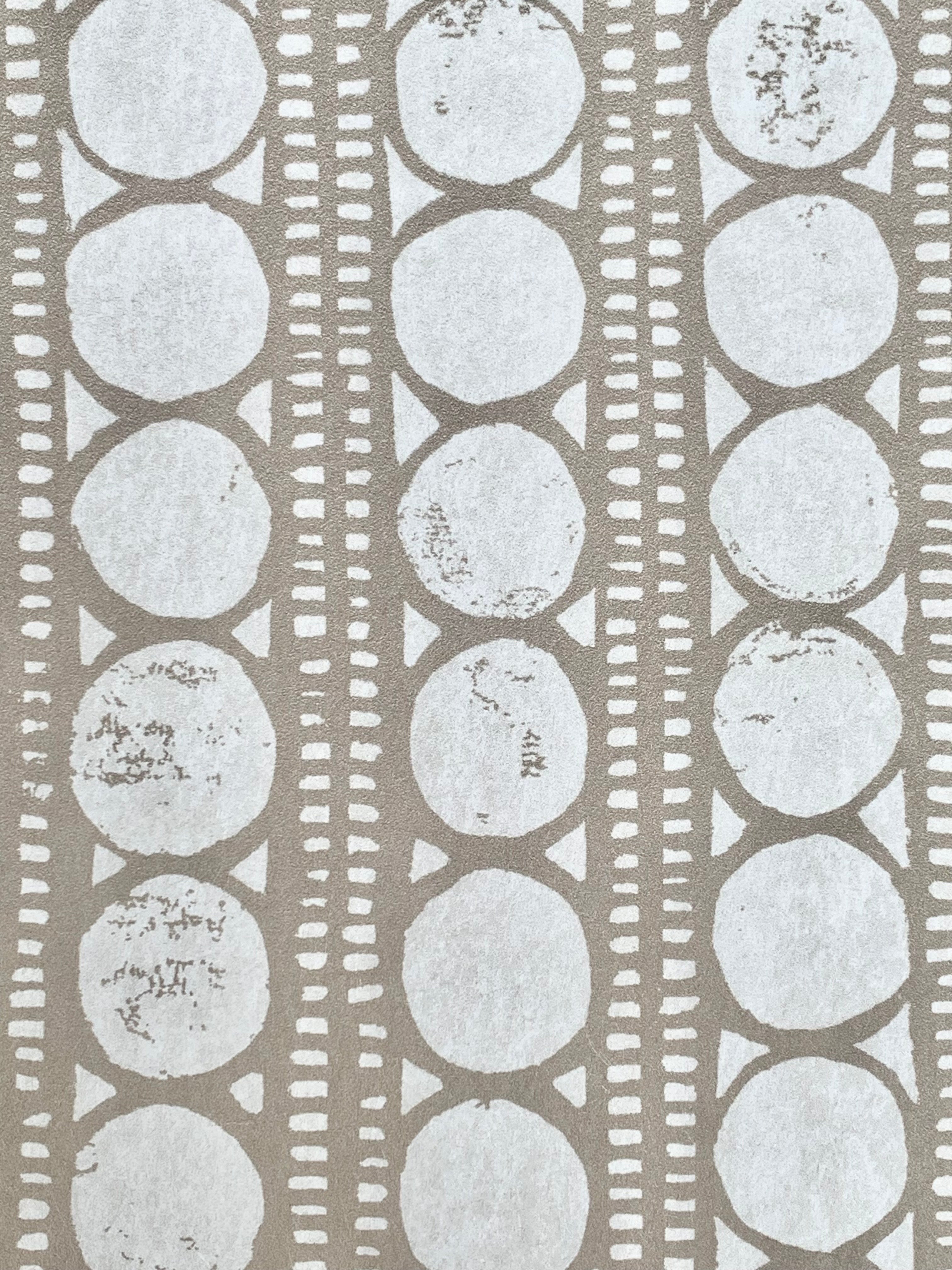 Detail of wallpaper in a circle and stripe print in white on a oatmeal field.